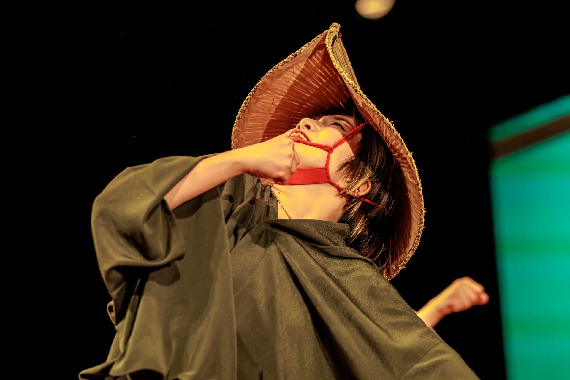 笠を目深にかぶり、身を反らせて舞う踊り手